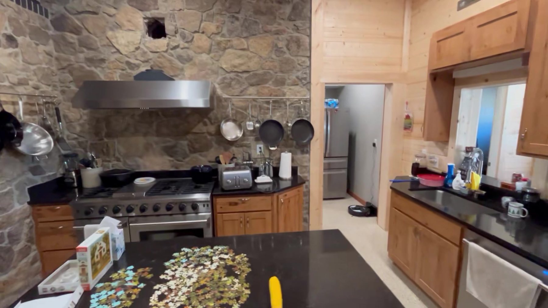 Sandstone range wall with a stainless hood and hanging pans