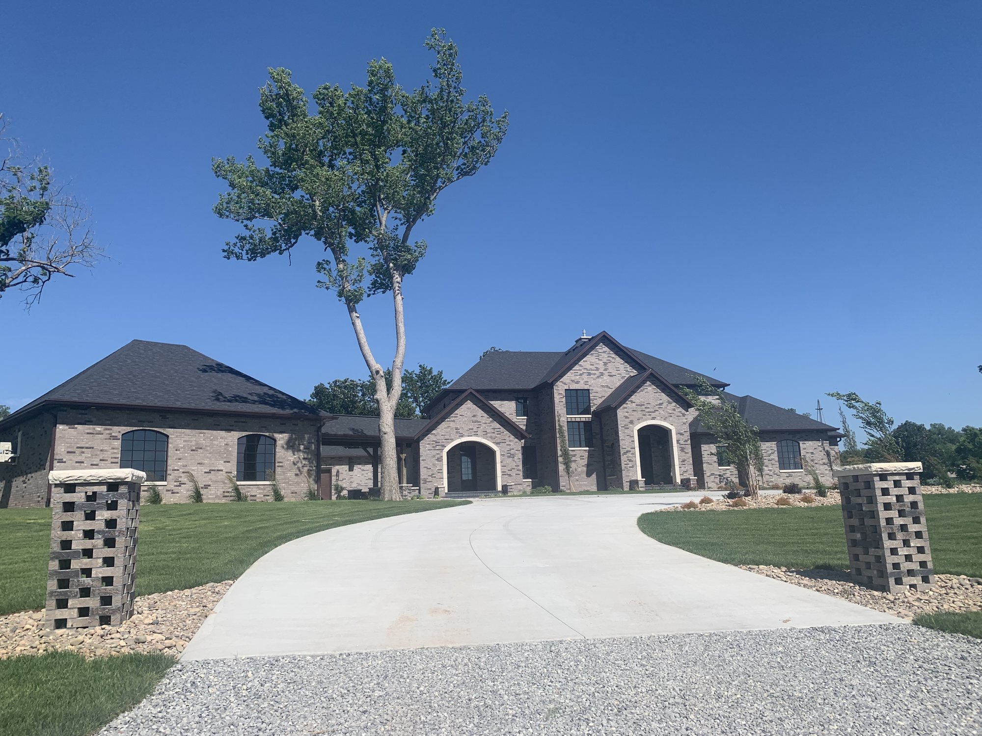 Cut stone and custom brick house with arched entryways
